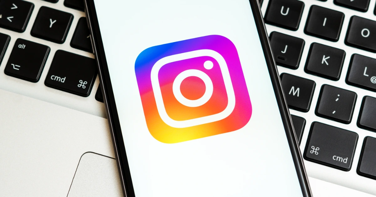 Smartphone displaying the Instagram app icon resting on a MacBook keyboard
