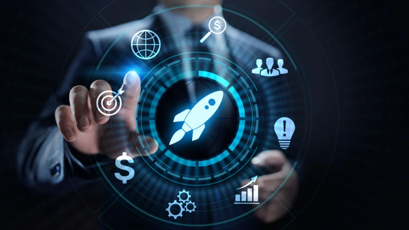 Suited man pointing at a glowing digital interface with rocket icon and business growth icons on dark background