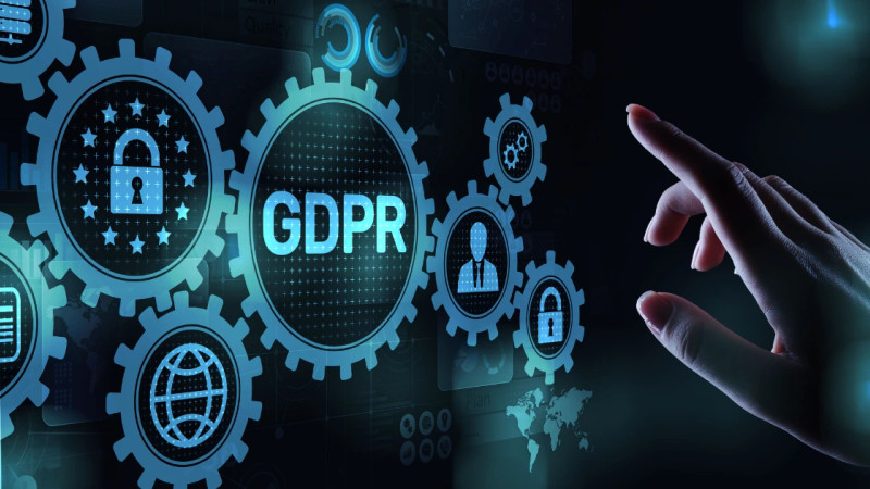 Hand pointing at glowing GDPR digital interface with gear icons, padlocks and globe symbols on dark background
