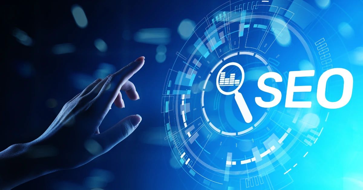 Hand pointing at a glowing blue digital interface displaying the word SEO and a magnifying glass icon