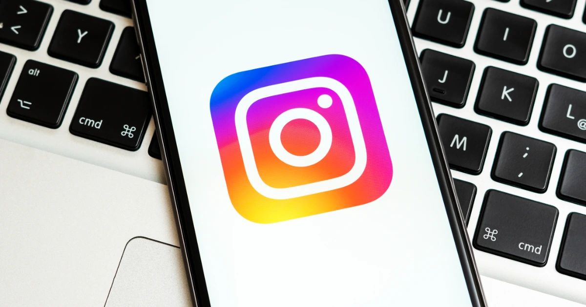 Smartphone displaying the Instagram app icon resting on a MacBook keyboard