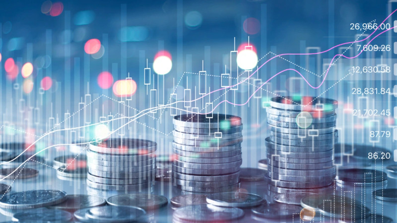Stacked silver coins with digital candlestick chart and rising trend lines overlaid on blue bokeh background