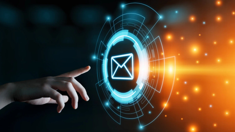 A hand pointing toward a glowing blue digital email envelope icon with circular tech rings on dark background